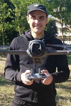 Massimiliano Zeuli pilota un drone in un parco indossando la divisa ufficiale DJI.