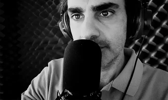 Massimiliano Zeuli al lavoro. Il suo volto è dietro un microfono di registrazione professionale.